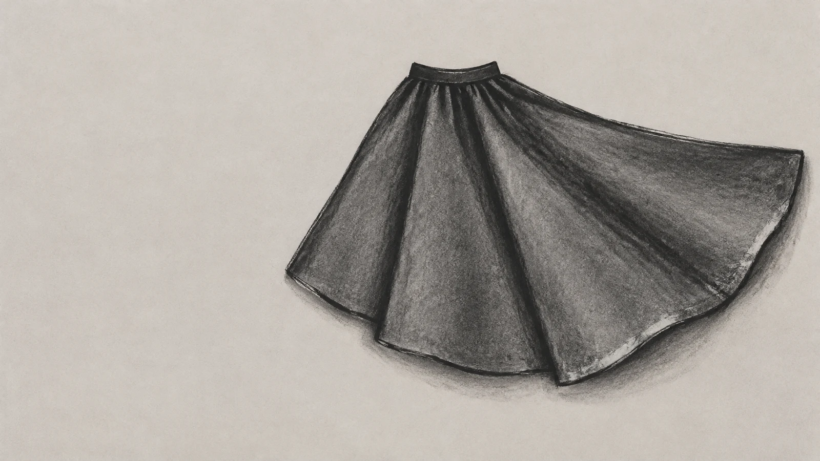 A dark charcoal-drawn skirt lies flat on a pale warm-grey textured surface, with a small curved waistband, broad flared hem, and several shaded folds; the left…