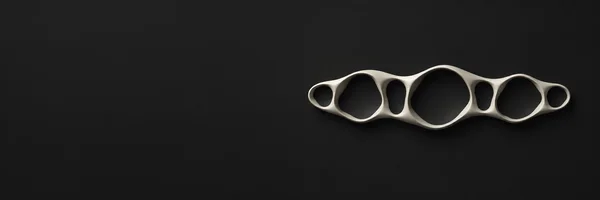 A connected ivory cellular ribbon with seven irregular dark openings sits right of center on a charcoal background, with softly lit raised edges and subtle…