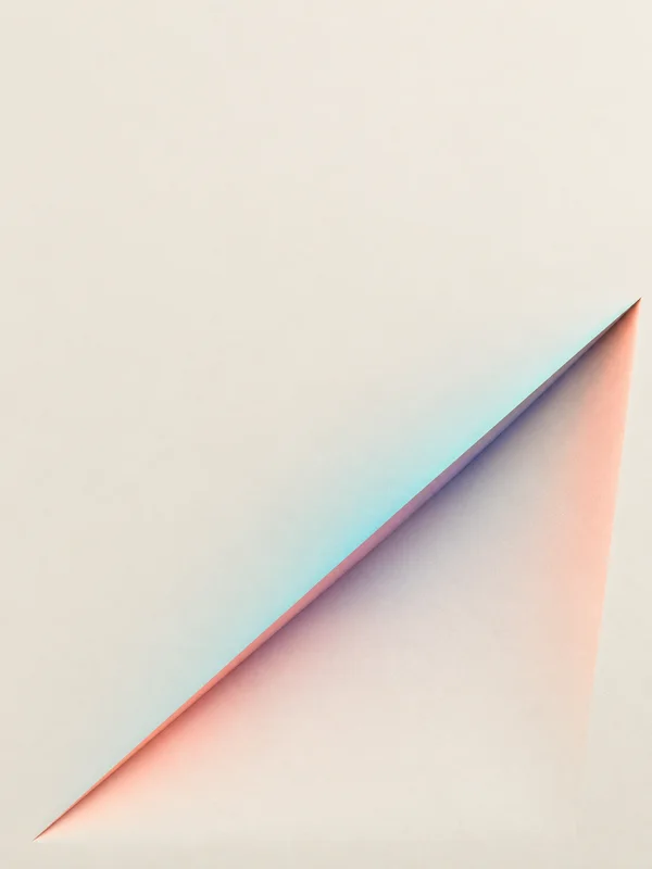A warm ivory textured plane with a broad diagonal triangular cut and a shaded sloping interior; cyan, coral and muted violet light bands trace the sharp edge…