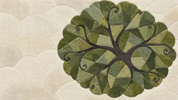 A large rounded tree canopy made of angular green quilt pieces fills the right side of an ivory stitched fabric design.