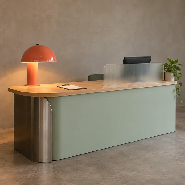 A pale mint clinic registration counter with a plywood top, curved steel end support, coral-orange dome lamp, frosted privacy screen, partly visible monitor…