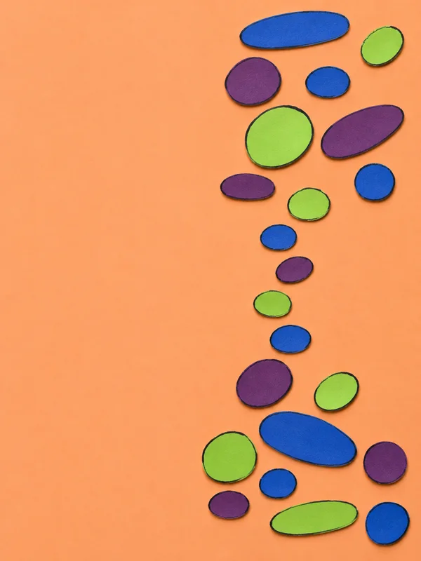 A handmade scatter-plot motif of separate cobalt, plum, and lime paper ovals on a warm-apricot background, with dark wobbly outlines and small shadows.