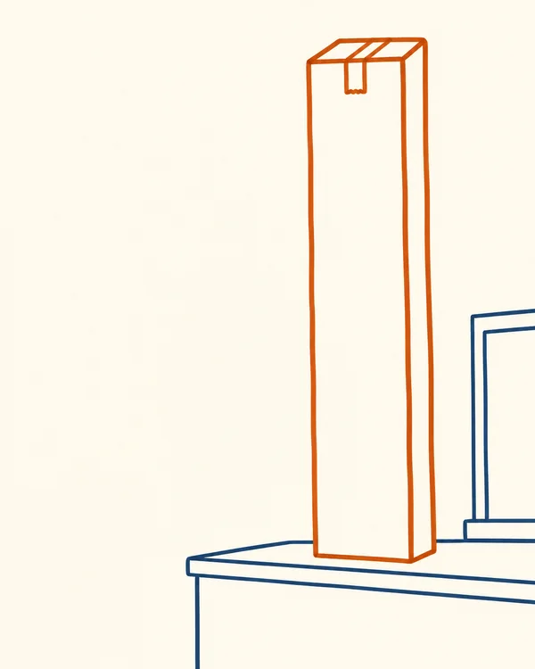 A very tall, narrow cardboard parcel outlined in burnt orange stands upright on a dark-blue counter, with a partial service-hatch outline at the right against…