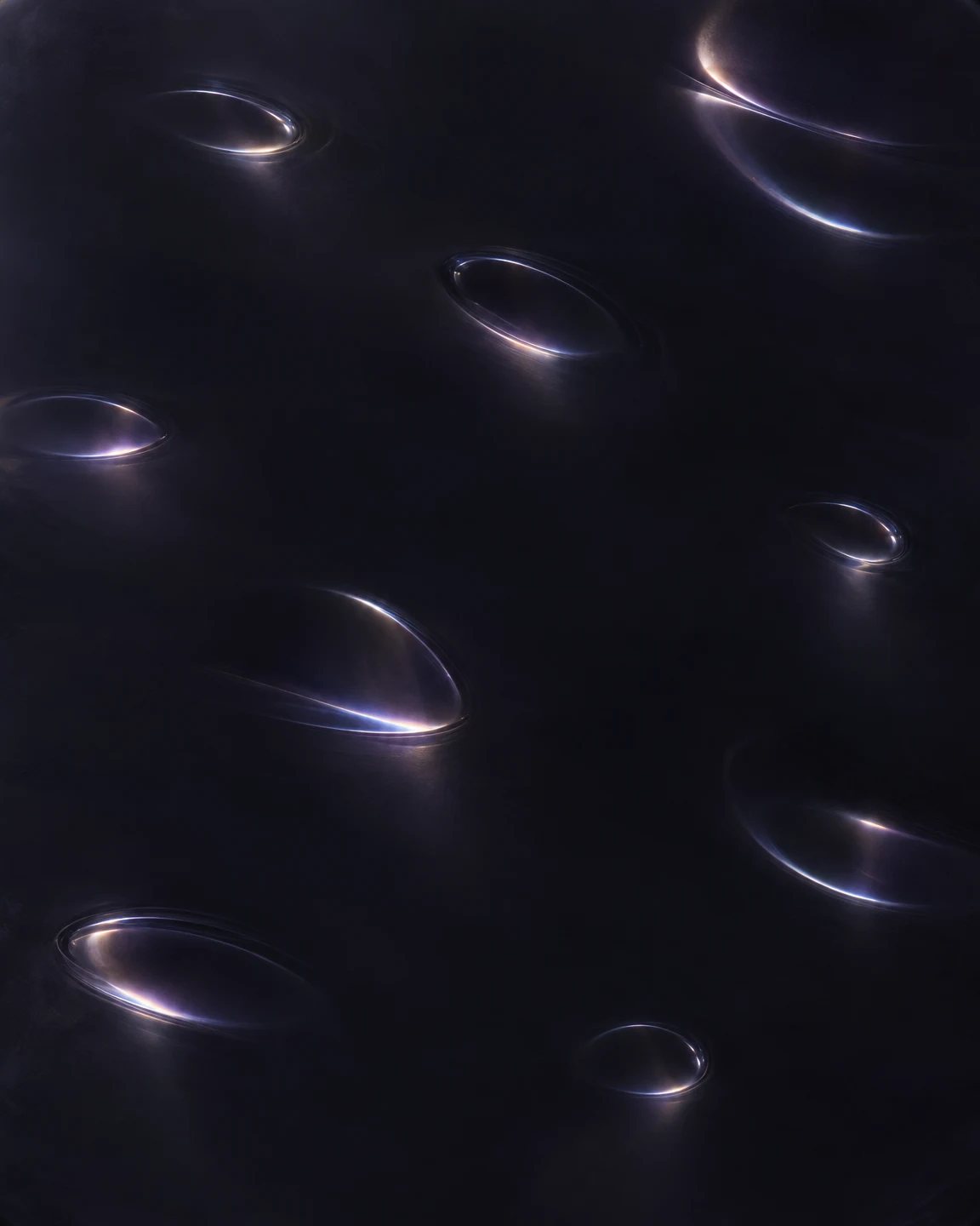 A near-black, subtly violet surface is dotted with scattered oval and crescent-shaped reflections in cool blue and soft warm light, with broad areas of…
