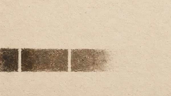 A charcoal-brown, roughly horizontal pigment band with two narrow pale interruptions crosses the lower-middle of a warm flax-colored paper field.