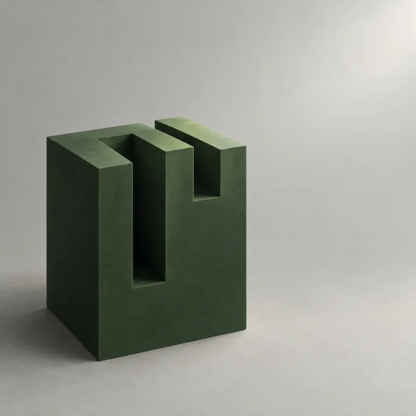 A dark evergreen-green rectangular block with deep rectangular slots stands against a pale grey background, lit from the upper right and casting a soft shadow…