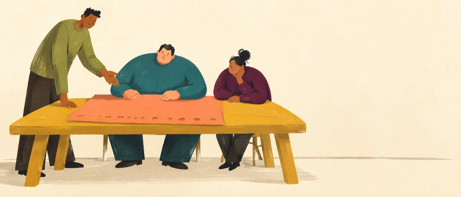 A standing instructor gestures toward a coral sheet with a row of round holes on a wide ochre table, while two seated adults watch; the group is arranged on…