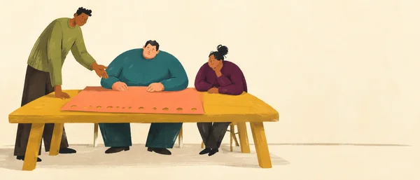 A standing instructor gestures toward a coral sheet with a row of round holes on a wide ochre table, while two seated adults watch; the group is arranged on…