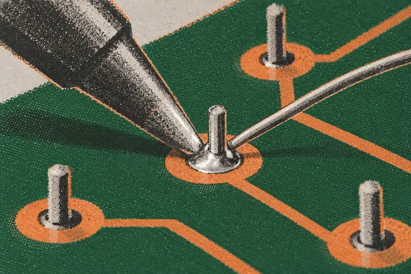 A cropped soldering iron tip and thin metal wire meet at a protruding lead on a copper-orange pad, against a pine-green circuit board with nearby pads and…