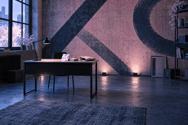 A black metal desk stands in a moody urban studio with a large graphic mural on the concrete wall.