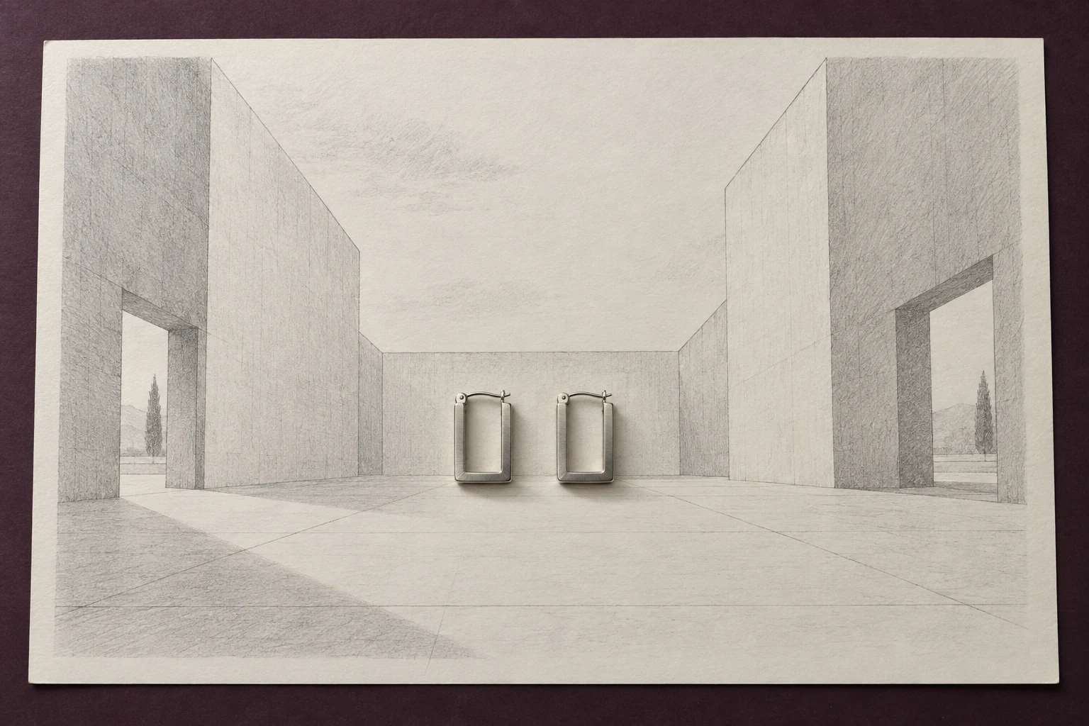 An ivory drawing sheet lies on a dark plum surface, showing a graphite perspective of an open courtyard with tall wall planes and small trees visible through…