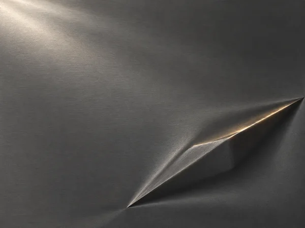 A graphite-grey textured metallic surface with a long angular ridge sweeping diagonally across the lower-right area, edged by a warm bronze highlight and dark…