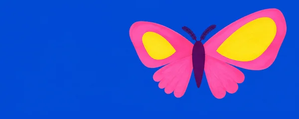 A large hot-pink moth with two yellow wing patches, a dark plum body and feathery antennae sits on the right against a cobalt-blue background, leaving broad…