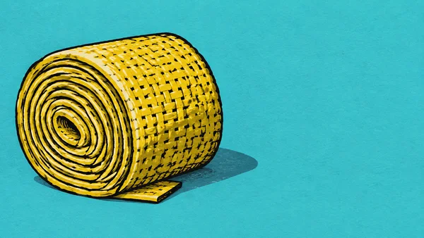 A sunflower-yellow woven fabric roll lies on a bright turquoise surface, its large spiral end facing forward and a short loose flap resting at its base.