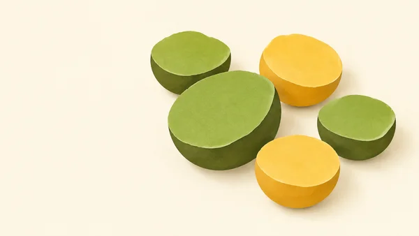 Five thick split-pea halves—three green and two yellow—form a loose cluster on a warm cream ground, with the largest green half near the centre.