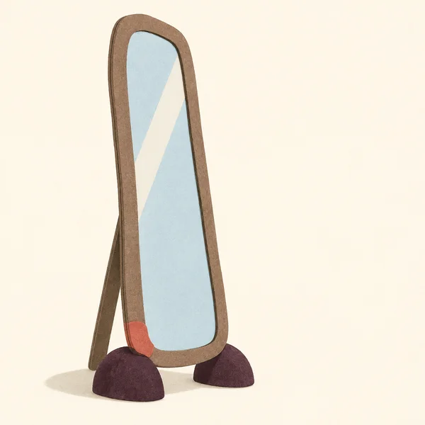 A tall, narrow rounded mirror with a warm taupe frame, pale blue inset and broad ivory diagonal gleam stands on two deep plum feet against a warm cream…