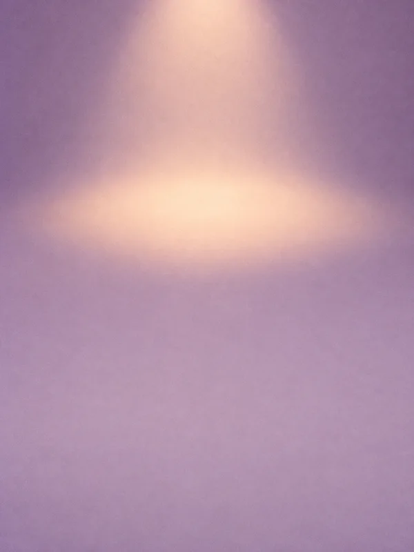 A matte lavender surface fills the portrait frame, with a softly feathered peach-colored oval of light above the center and fine visible texture throughout.