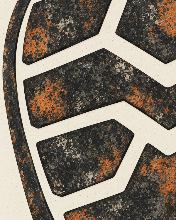 A close-up abstract tread pattern with dark, angular rubber-like forms, pale branching channels, and mottled charcoal, rust-orange, and light flecks; a curved…