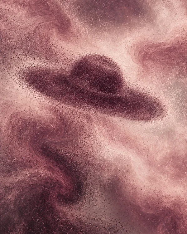 A dusty-rose and pale-blush granular abstract field with flowing dark aubergine patches; a rounded central patch loosely suggests a broad-brim hat.
