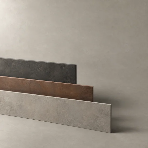 Three long, mottled rectangular slabs in charcoal, rust-brown and warm grey stand in staggered rows on a grey surface against a matching plain backdrop.