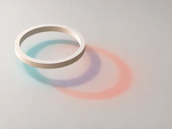 A matte ivory ring floats above a pale warm-grey surface, casting soft cyan and coral shadows that overlap in muted violet and extend toward the lower right.