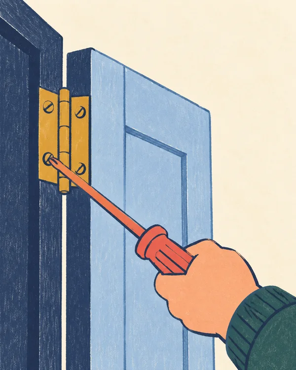 A peach mitten-like hand in a dark green sleeve holds a long coral screwdriver against a mustard hinge on a pale-blue door and navy frame, with warm ivory…