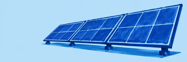 Three connected cobalt-blue solar panels stand on short block supports, angled upward across a pale-blue outdoor ground with a long blue shadow beneath them.