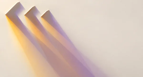 Three angular beveled forms near the upper-left edge cast long amber and muted violet shadows across a smooth ivory surface, leaving much of the right side…
