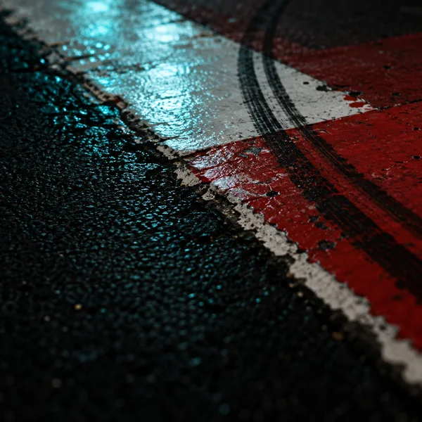 A rain-wet red-and-white racetrack curb meets dark asphalt, with parallel black rubber marks crossing the paint and cyan reflections glistening on the surface.