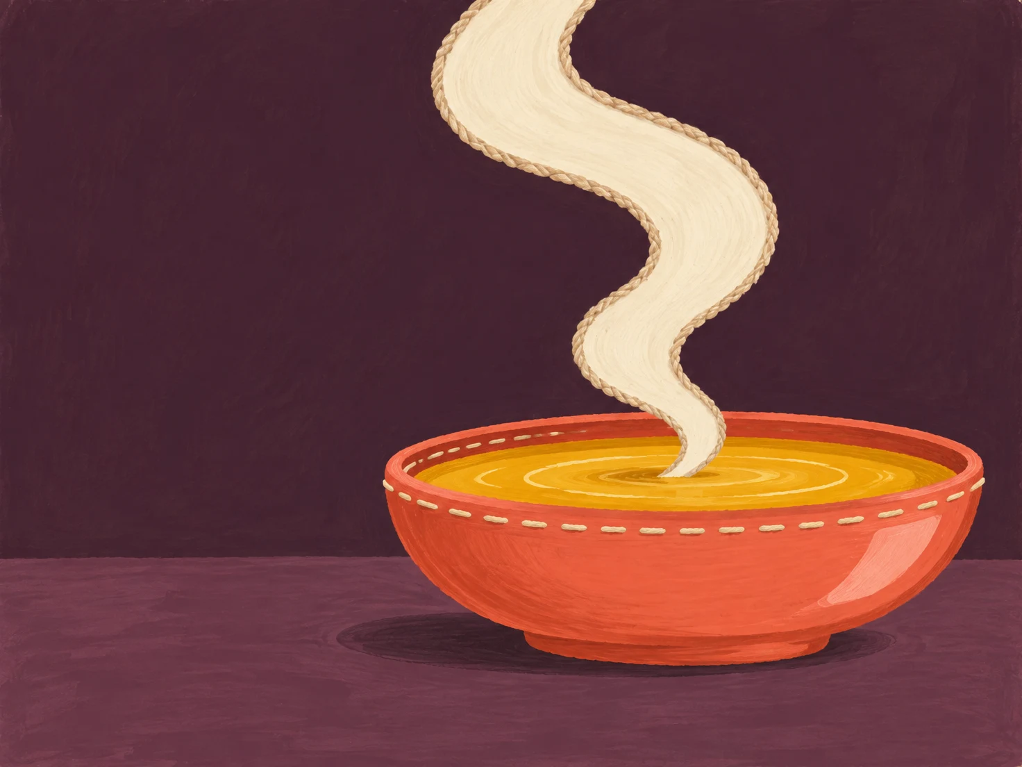 A wide coral bowl filled with golden soup sits on a muted plum tabletop against a dark aubergine background.