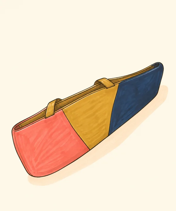A long diagonal handbag illustration on a warm cream background, with coral, ochre and deep navy panels, two ochre handles and a pale peach shadow.