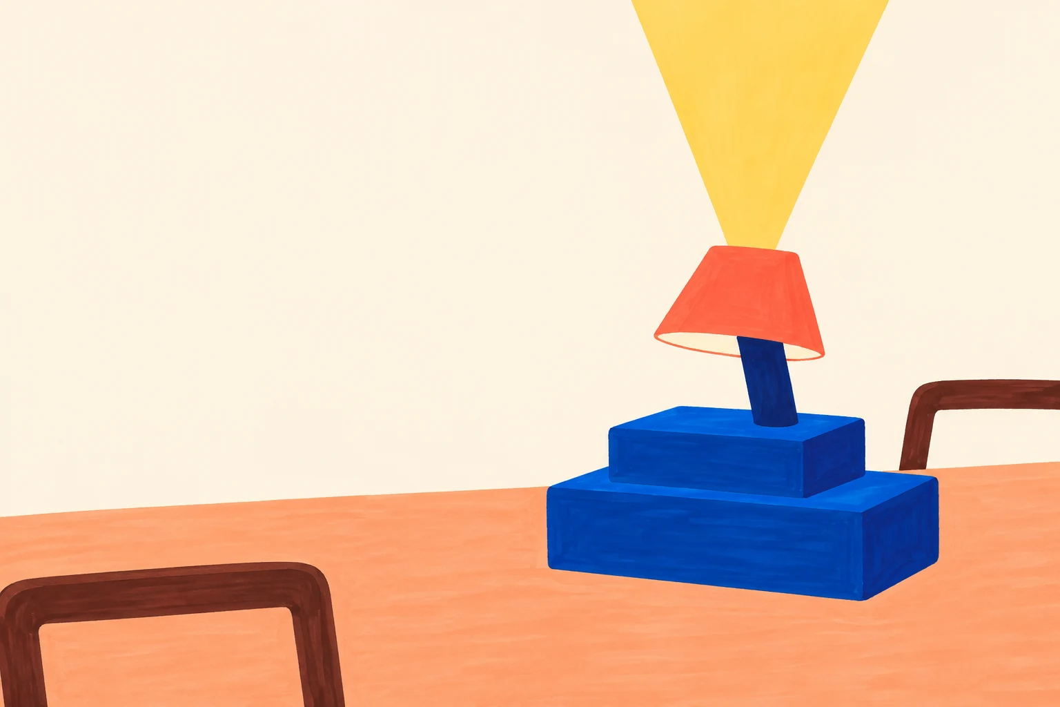 A squat blue two-tier desk lamp with a short stem and coral trapezoid shade sits on a peach tabletop.