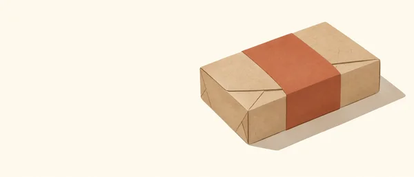 A closed kraft-paper rectangular mailer with folded triangular seams and a broad terracotta band sits on the right side of a warm ivory background, casting a…