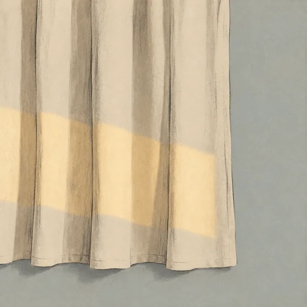 A hand-drawn ivory linen curtain hangs in long folds, with an uneven hem above a pale blue-grey wall and warm afternoon light falling across its lower half.